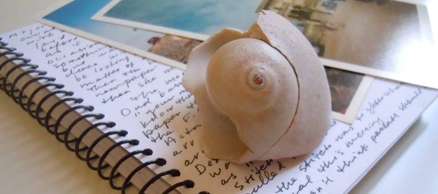 creative writing journal with seashell and photographs