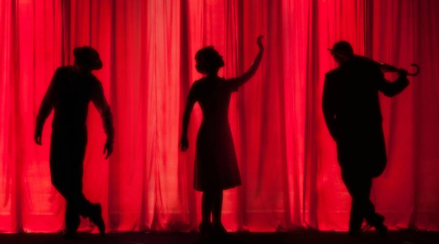 silhouettes against theater curtain